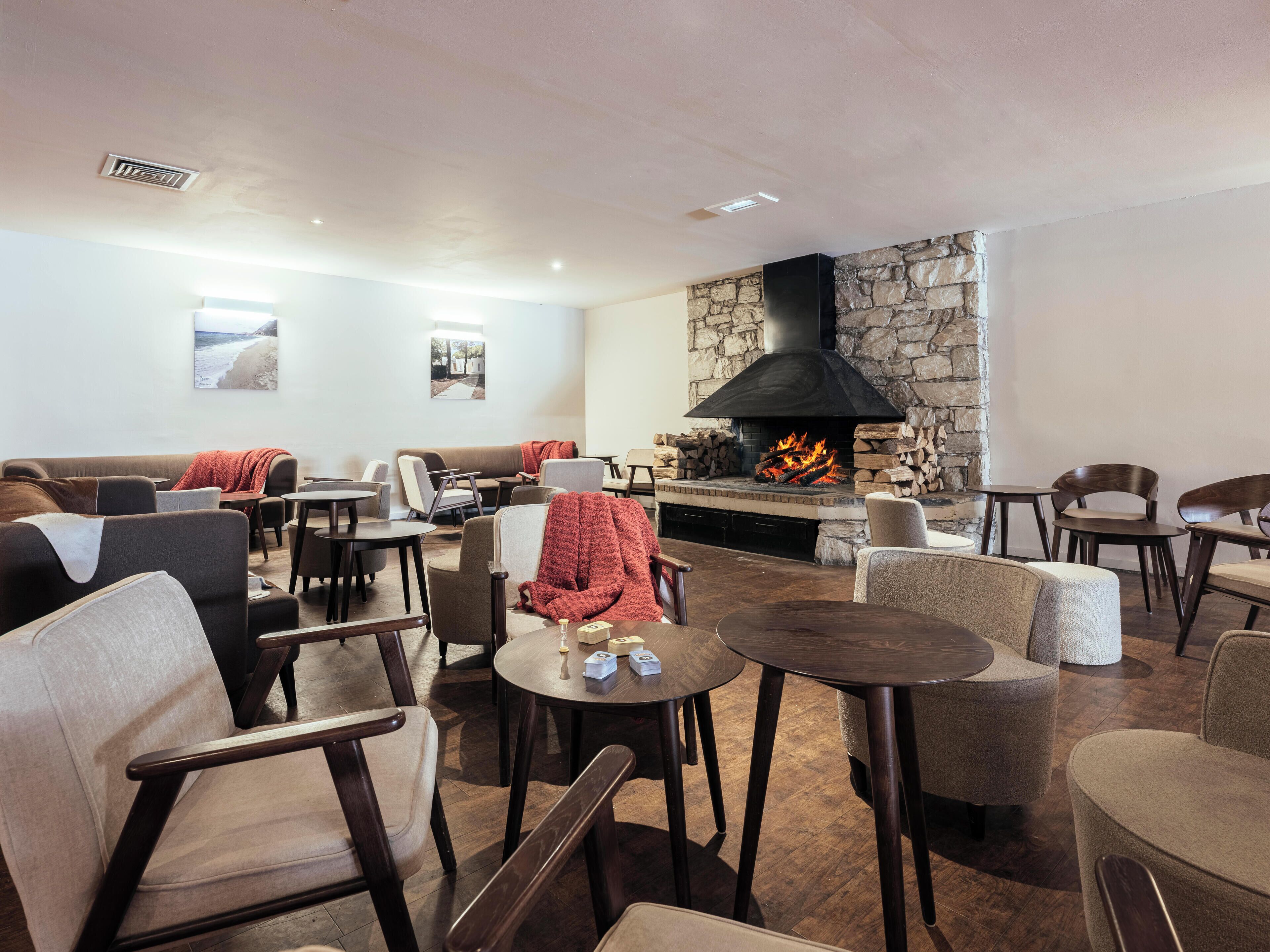 A cozy indoor seating area with sofas, chairs, and a fireplace.