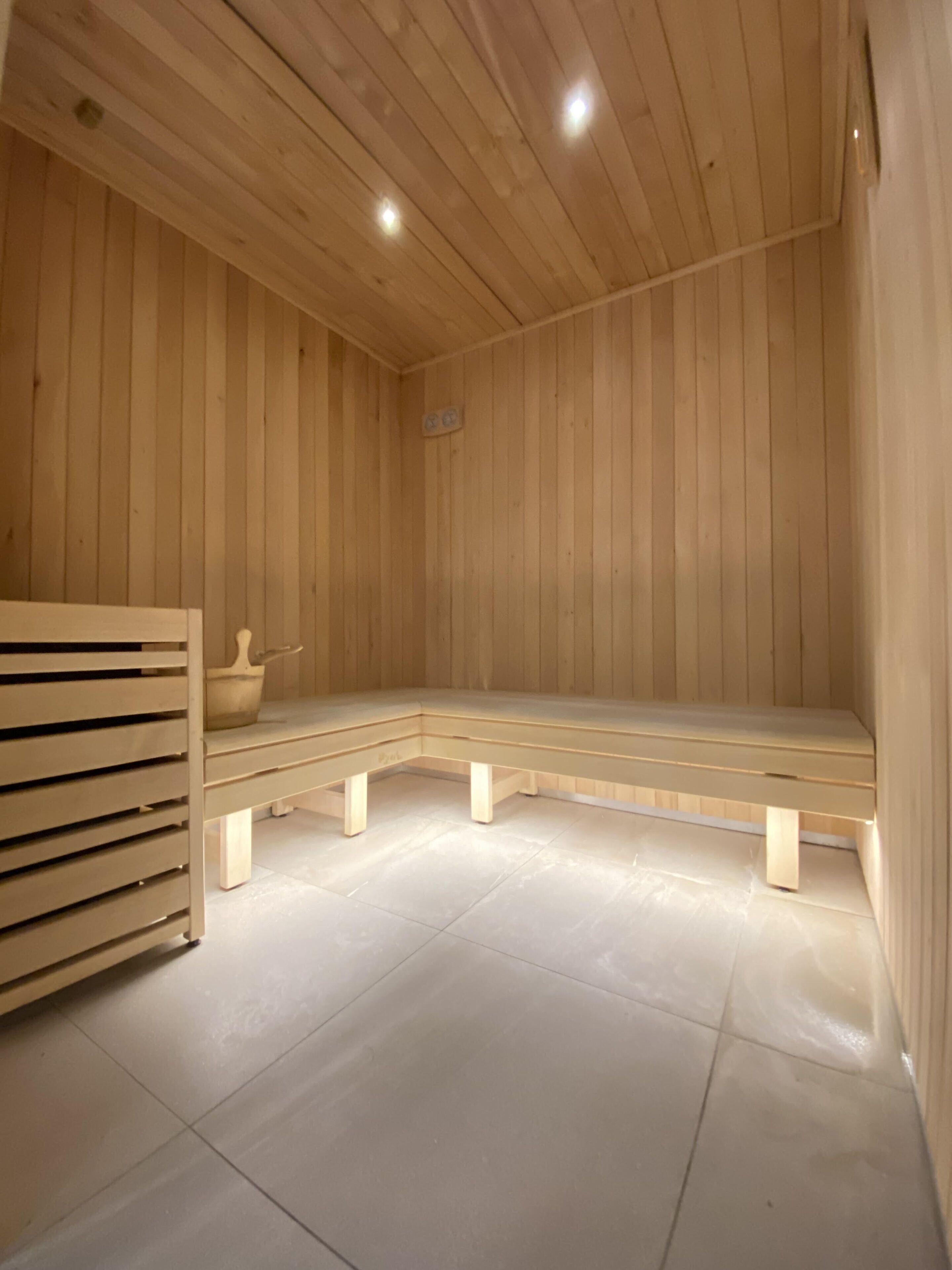 A wooden sauna with benches and a bench on the floor.