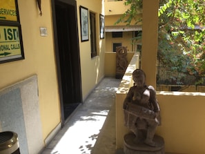 A corridor with a statue, a sign for 'ISD National Calls', and a door leading to another room.