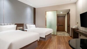 Habitació d'hotel amb dos llits, televisió i bany.
