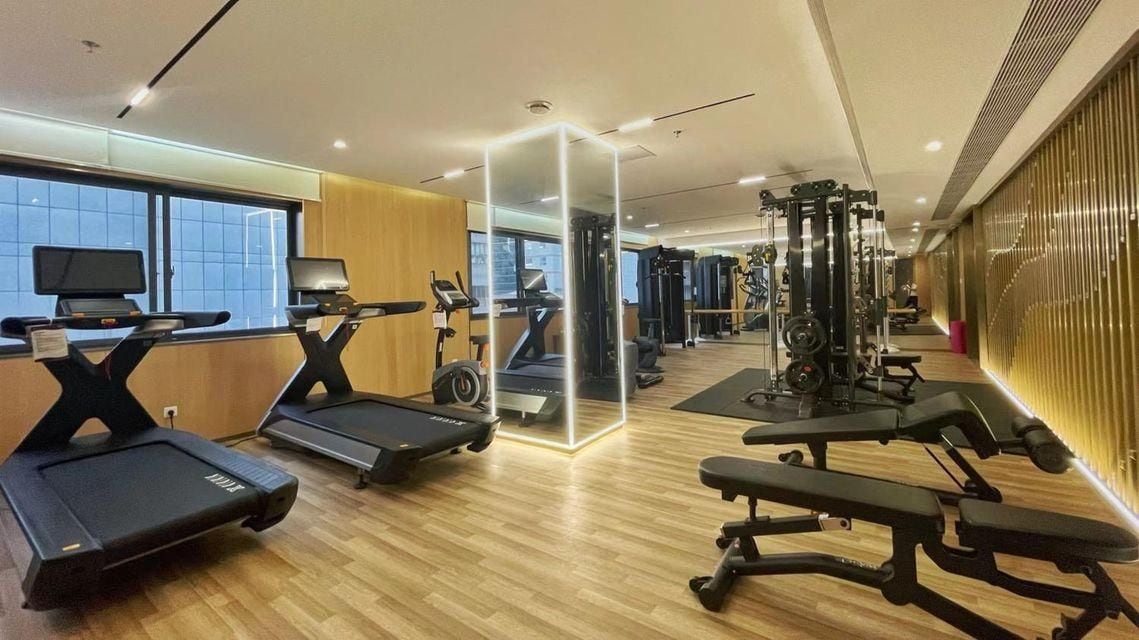 A gym with treadmills, a mirrored wall, and exercise equipment.