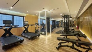 Un gimnàs amb cintes de córrer, un mirall gran i equipament d'exercici.