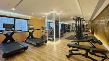 A gym with treadmills, a mirrored wall, and exercise equipment.