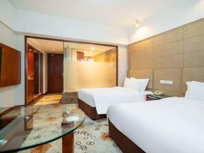 A hotel room with two beds, a glass table, and a mirror. - Tianfeng (Nanjing)