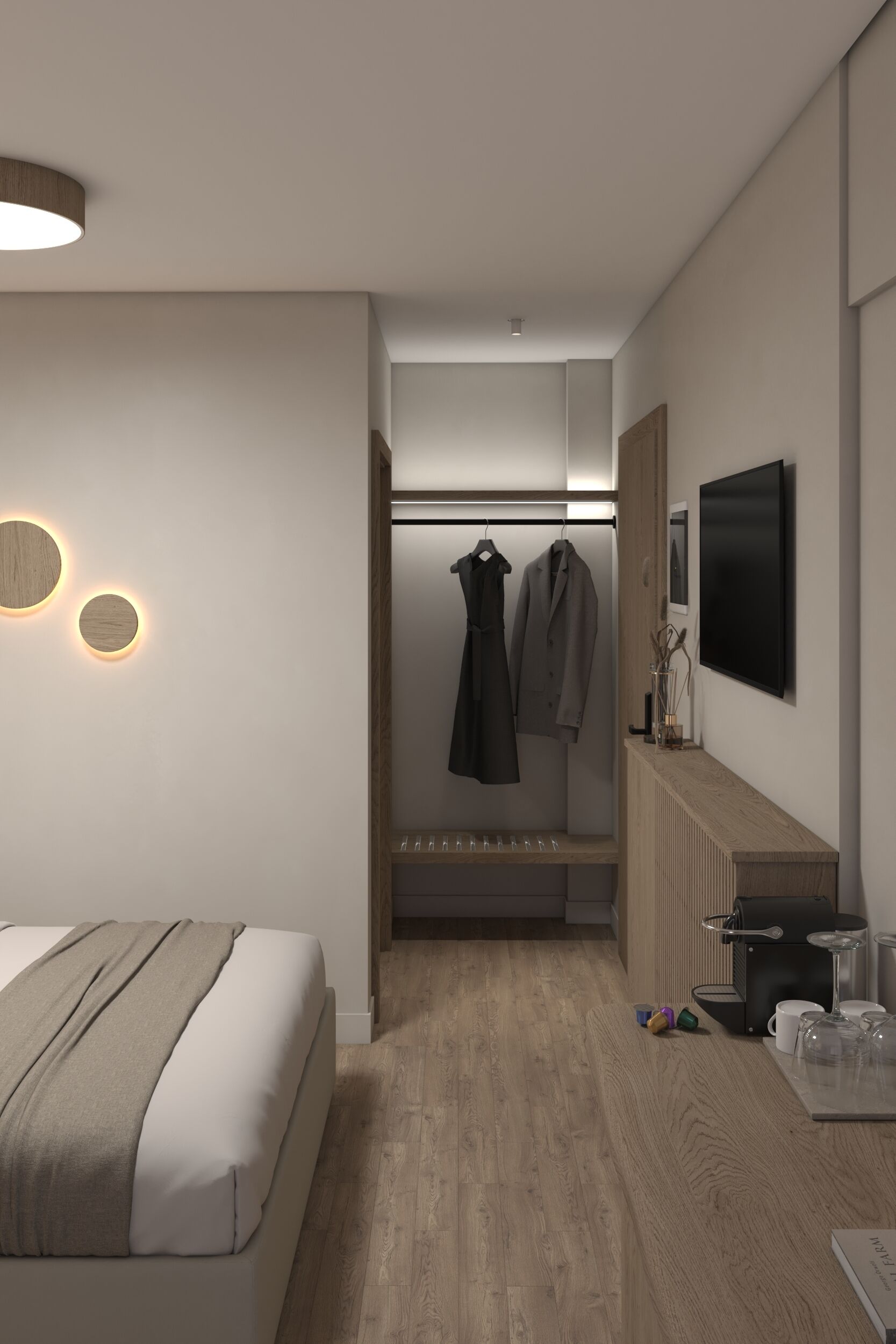 Ein modernes Hotelzimmer mit einem Bett, einer Sitzecke mit einer Kaffeemaschine und einem Kleiderständer.