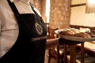 Una persona con delantal negro y logotipo, sosteniendo un plato con pasteles.