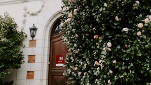 Un bâtiment de style architectural traditionnel, caractérisé par une entrée imposante avec une porte en bois et un balcon.