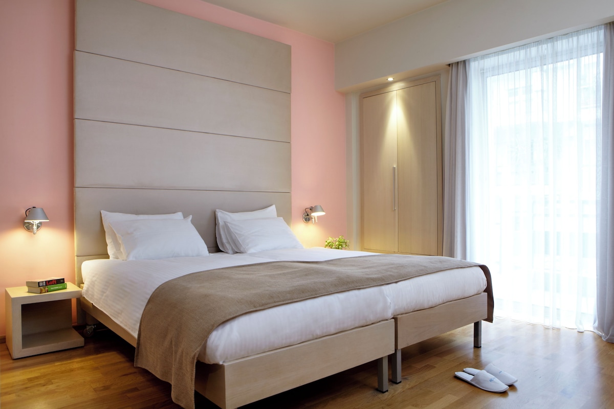 Une chambre à coucher moderne avec un grand lit, des lampes de chevet, une table de chevet et une armoire.