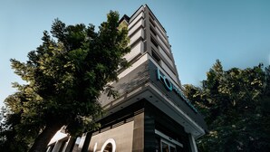 Un edificio moderno con un llamativo letrero 'LO', rodeado de árboles.