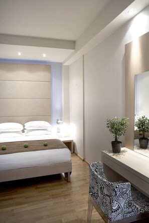 Une chambre à coucher moderne avec un lit, une table de chevet, une plante en pot et un miroir.