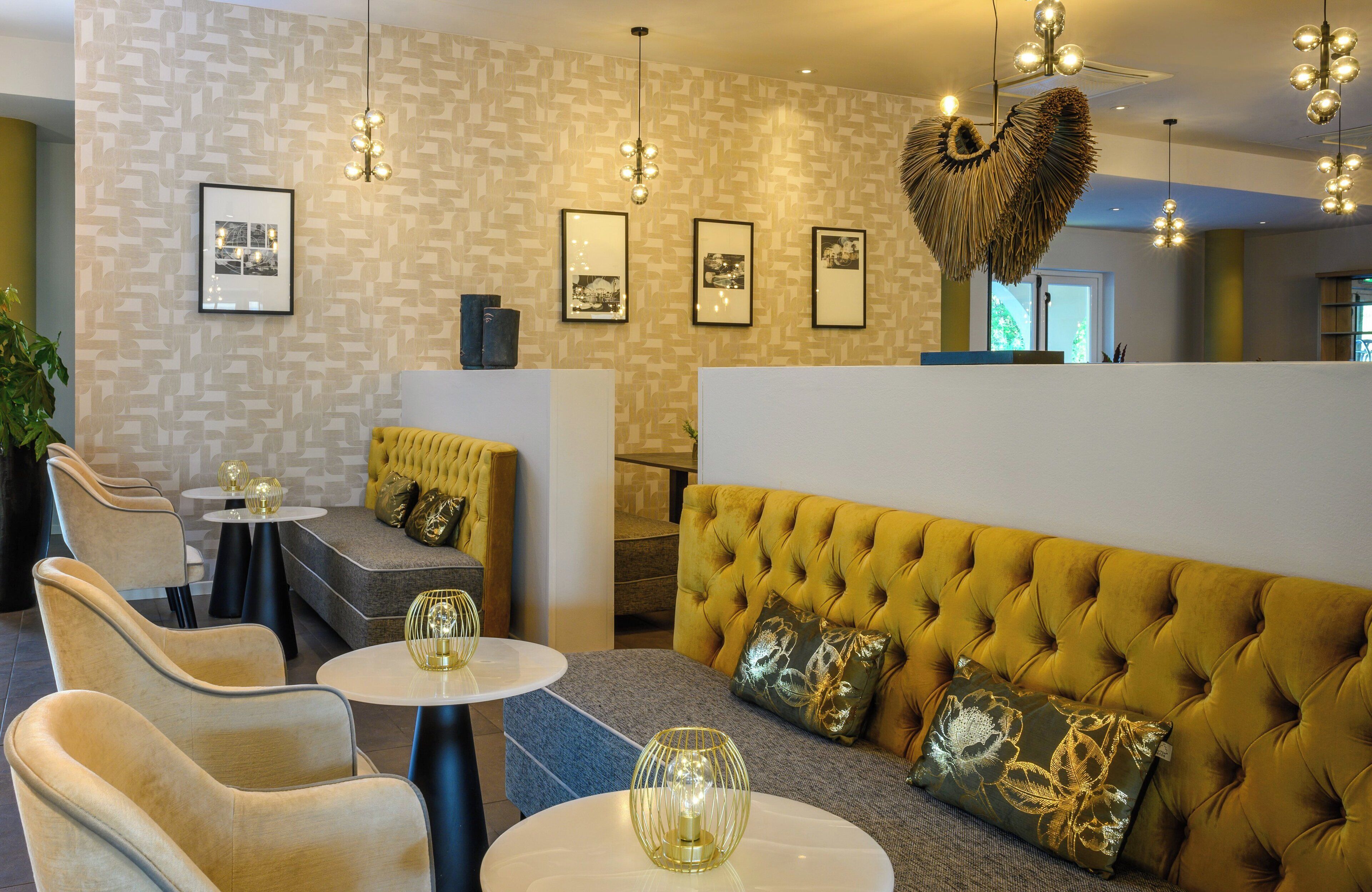 A modern interior with a tufted sofa, round tables, and framed pictures on the wall.