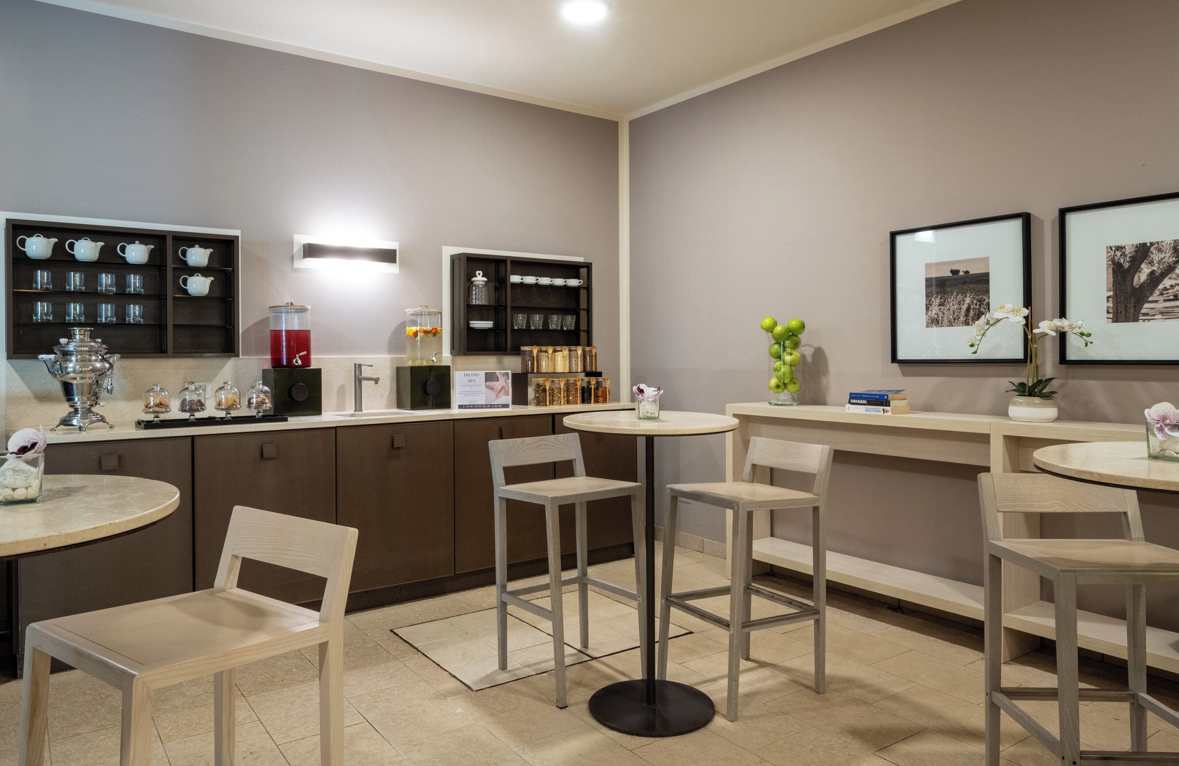 A modern cafe with a bar area, seating, and a display of tea sets and jars.
