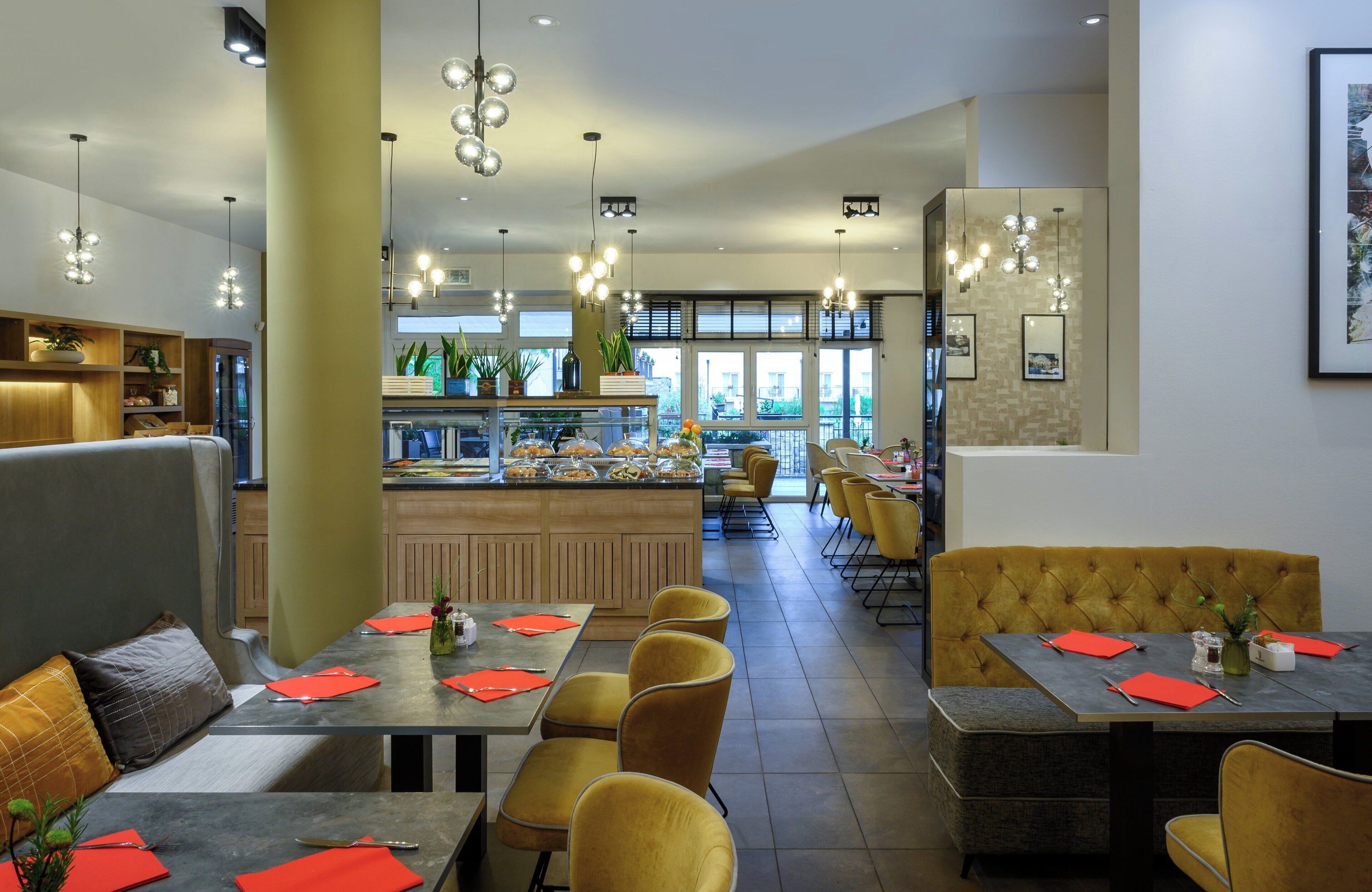 Un ristorante moderno con diverse aree dedicate alla ristorazione, tra cui un bar e un buffet.