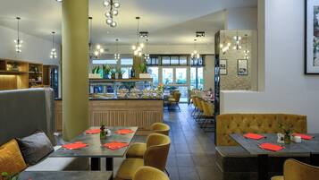 Un ristorante moderno con diverse aree dedicate alla ristorazione, tra cui un bar e un buffet.