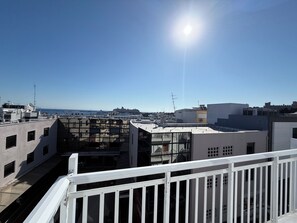 A rooftop with a white railing, a clear sky, and a distant view of a cruise ship. - Savoy City Hotel (Rhodes)