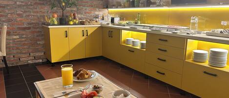 A breakfast setup with a table, plates of food, and a juice glass.