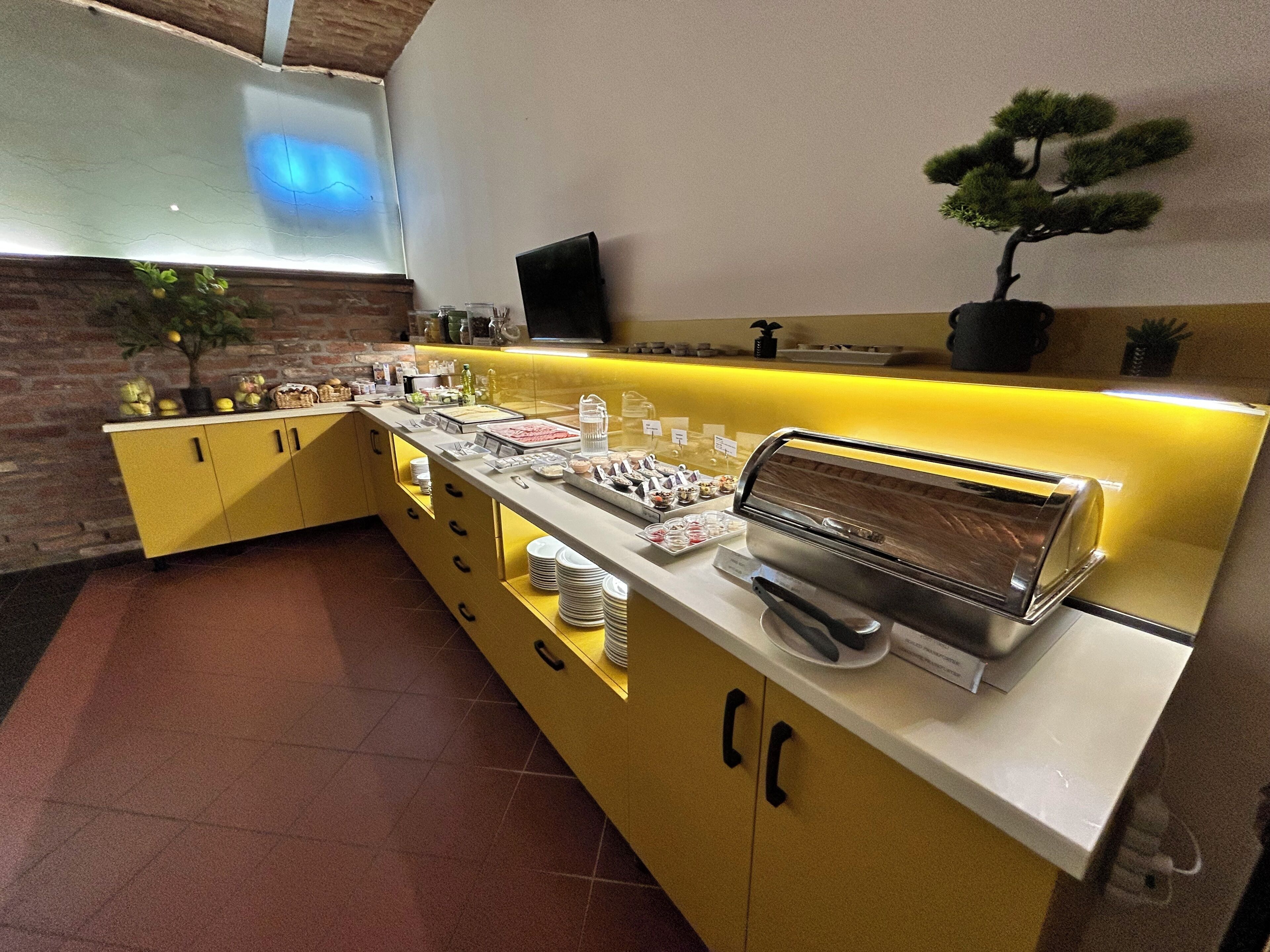 Un espace buffet proposant une variété de plats, une machine à café et une petite plante en pot.