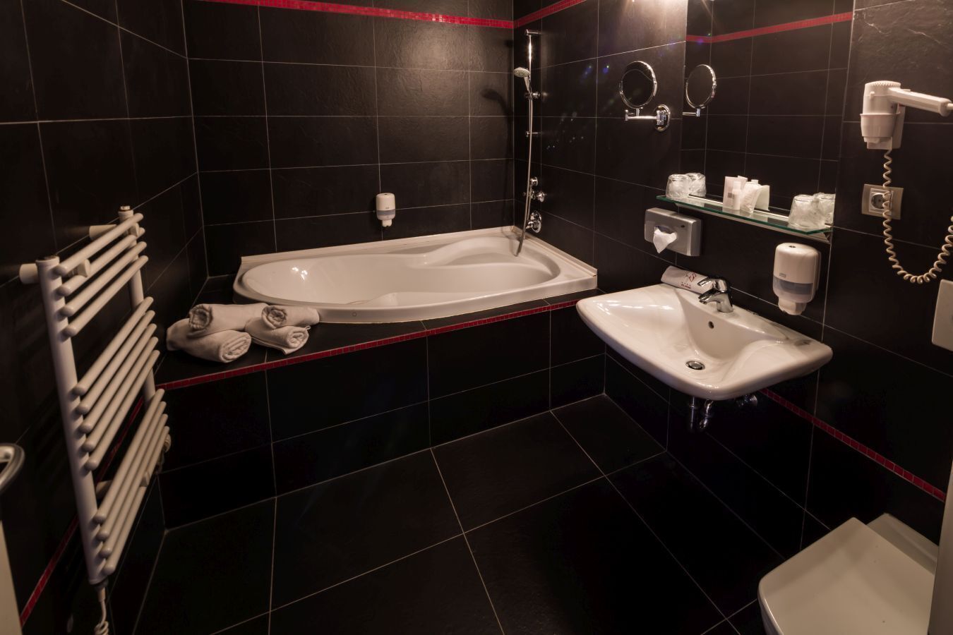 A modern bathroom with a bathtub, a sink, and a toilet.
