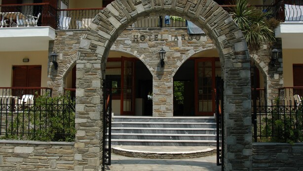 A stone archway with the words "HOTEL ARGOS" above a set of stairs leading to a building entrance.