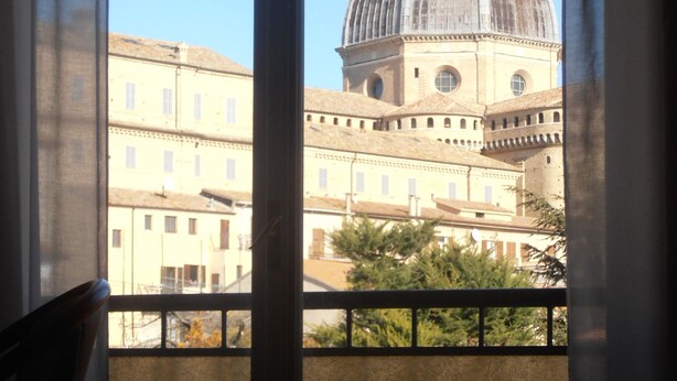 A room with a view of a historic building with a dome and bell tower. - San Gabriele (Loreto)