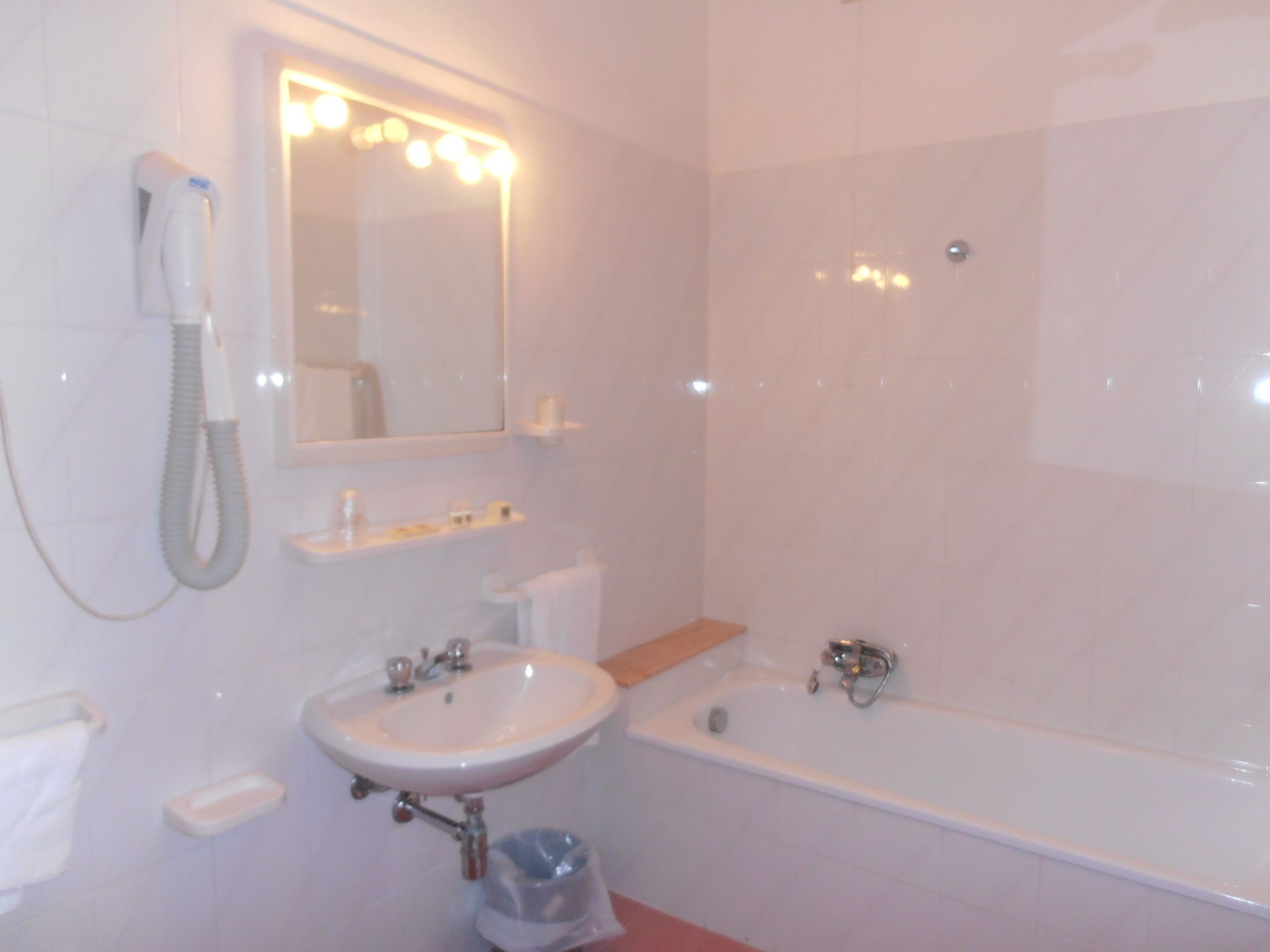 Un baño con lavamanos, espejo y bañera.