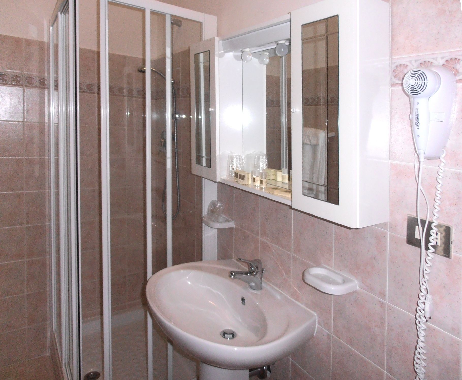 A bathroom with a sink, mirror, and hair dryer.