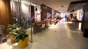 A modern interior with a reception desk, seating area, and potted plants. - ibis Buenos Aires Obelisco (Buenos Aires)