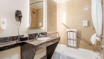 A bathroom with a sink, mirror, towel rack, and a shower area.