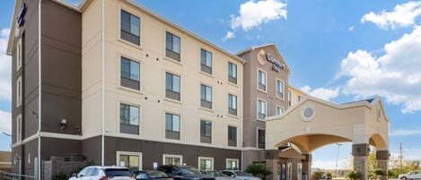 Un hotel Comfort Inn con un estacionamiento y varios coches aparcados al frente.