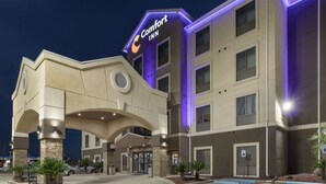 A Comfort Inn hotel with a modern design, featuring a prominent entrance, multiple floors, and a parking area.