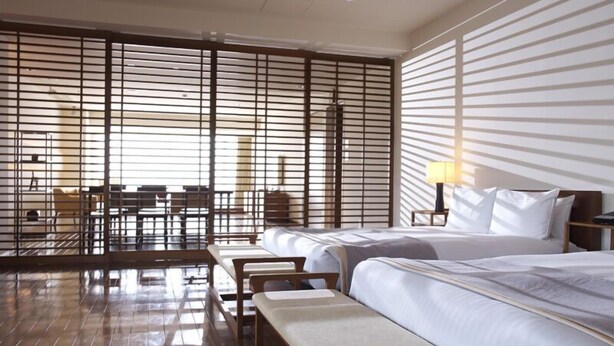 A hotel room with a large bed, a desk, a chair, and a bench. - Hotel CLASKA (Tokyo)
