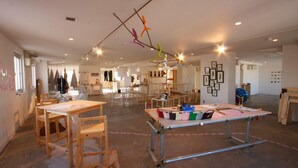An interior space with tables and chairs, wooden beams on the ceiling, and artwork on the walls. - Hotel CLASKA (Tokyo)