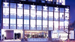 A modern hotel with a checkered facade, large glass windows, and a well-lit entrance. - Hotel CLASKA (Tokyo)