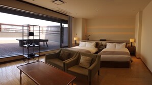 A hotel room with two beds, a sofa, a table, and a balcony with a table and chairs. - Hotel CLASKA (Tokyo)