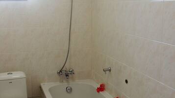 A bathroom with a bathtub, toilet, and shower.