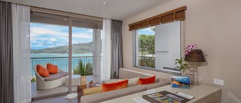 Una sala de estar moderna con balcón, ventanas amplias y vista al mar.