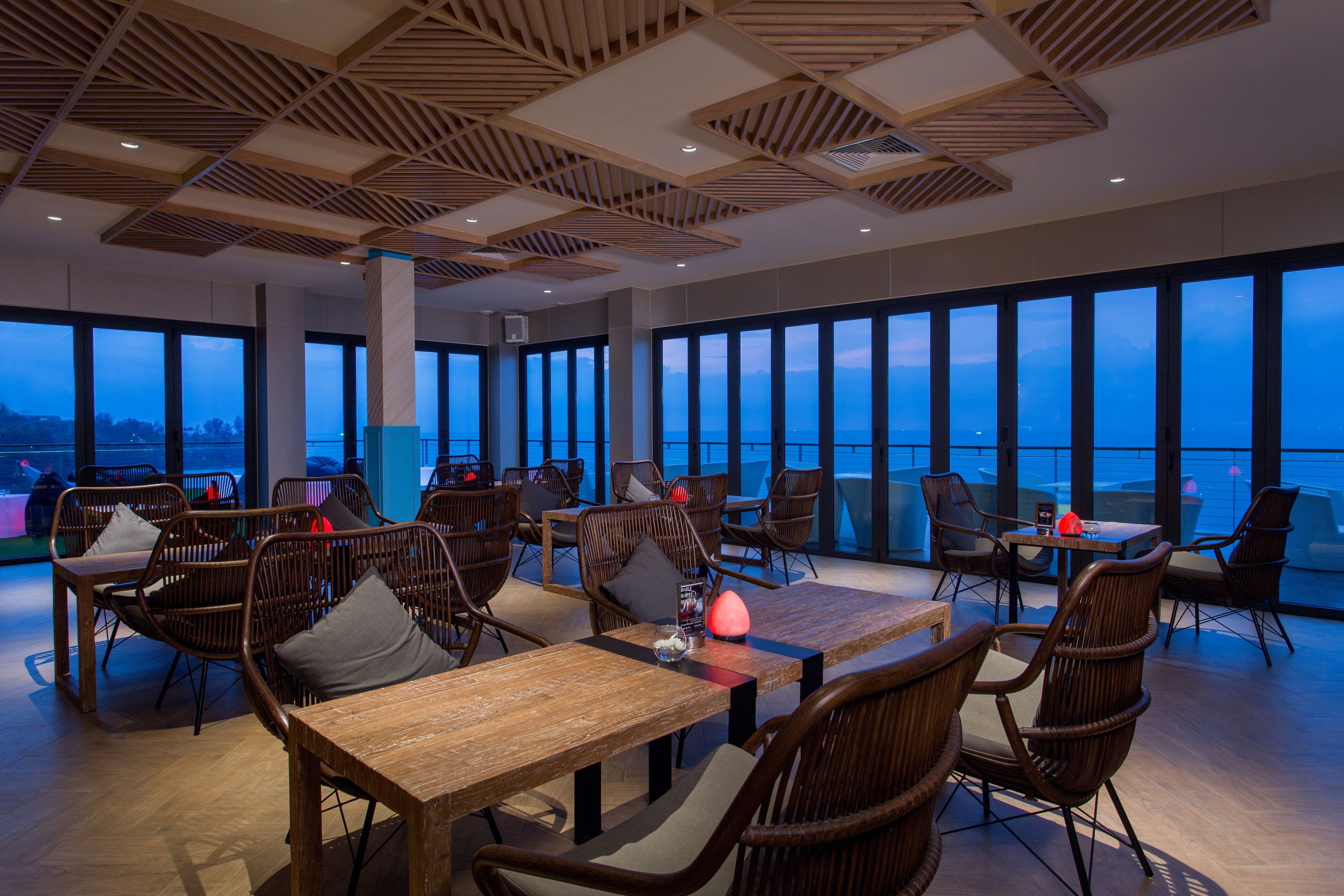 Un amplio comedor con techos altos y grandes ventanales que ofrecen vistas al cielo.