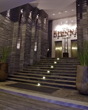 A modern hotel entrance with a stone facade, a staircase leading to the lobby, and a sign reading "CAPE STATION". - Cape Sienna Gourmet Hotel & Villas (Kamala)