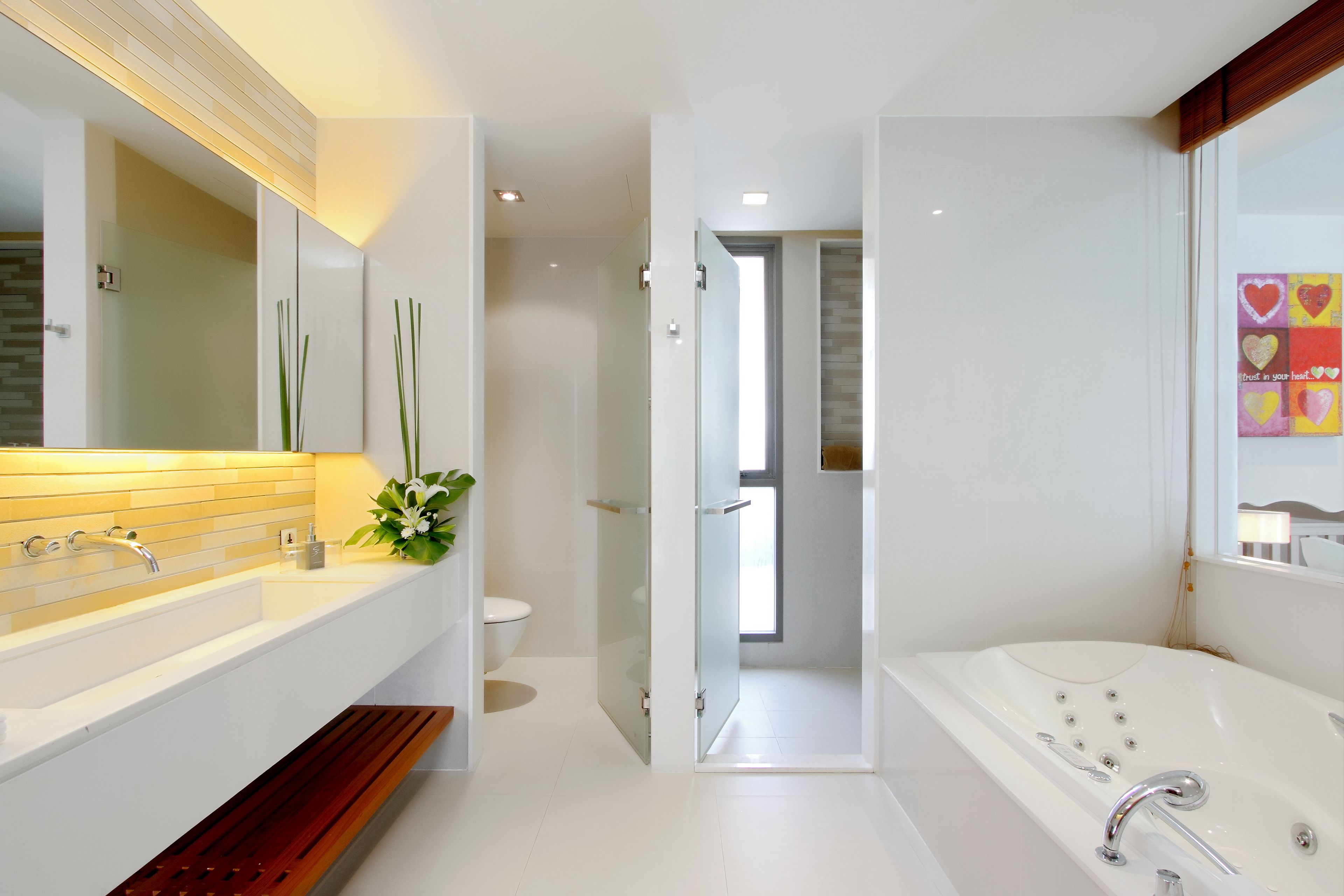 A modern bathroom with a large bathtub, a double sink vanity, and a glass shower enclosure.