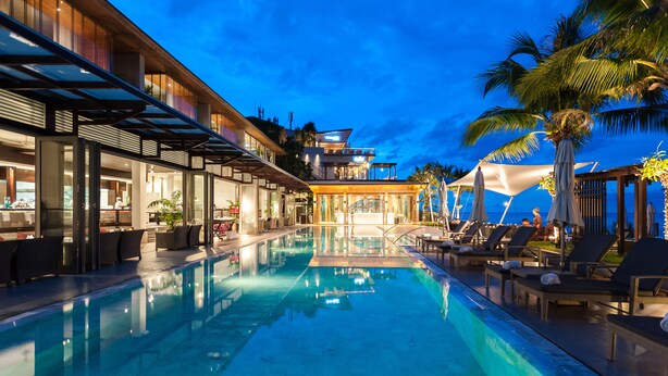 Un hôtel moderne doté d’une piscine, d’un espace extérieur aménagé et offrant une vue sur l’océan.