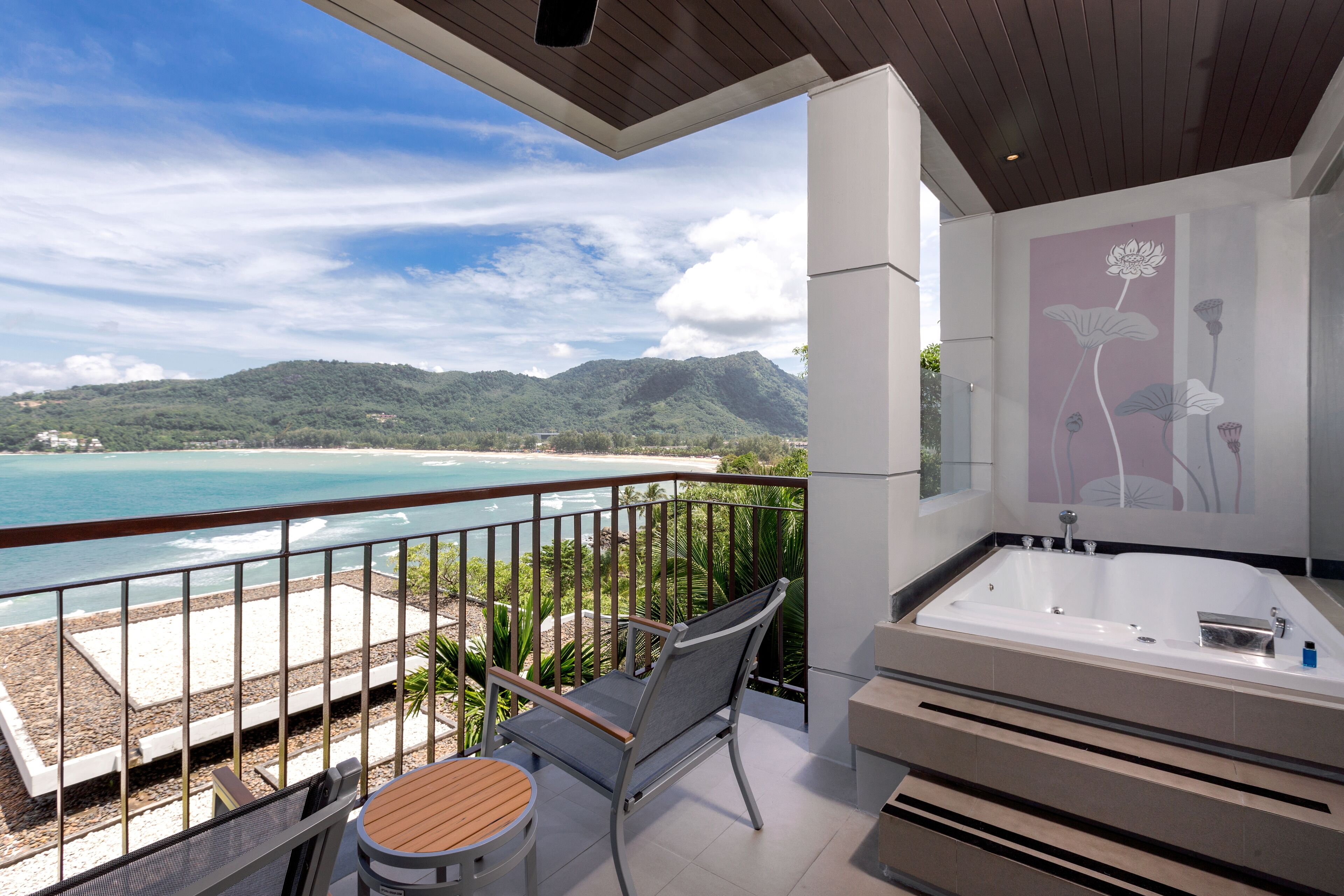 Ein Balkon mit Meerblick, einer Sitzecke und einer Whirlwanne.