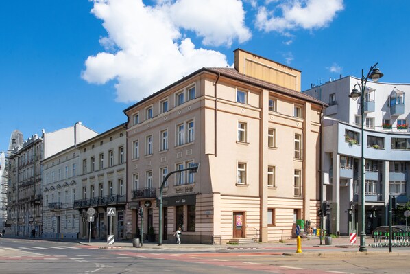 A multi-story building with a classic architectural style, featuring a ground floor with commercial spaces and upper residential units. - Aparthotel Globus (Kraków)