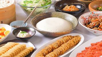 A variety of dishes including a bowl of rice, a plate of sliced meat, and several bowls of different foods.