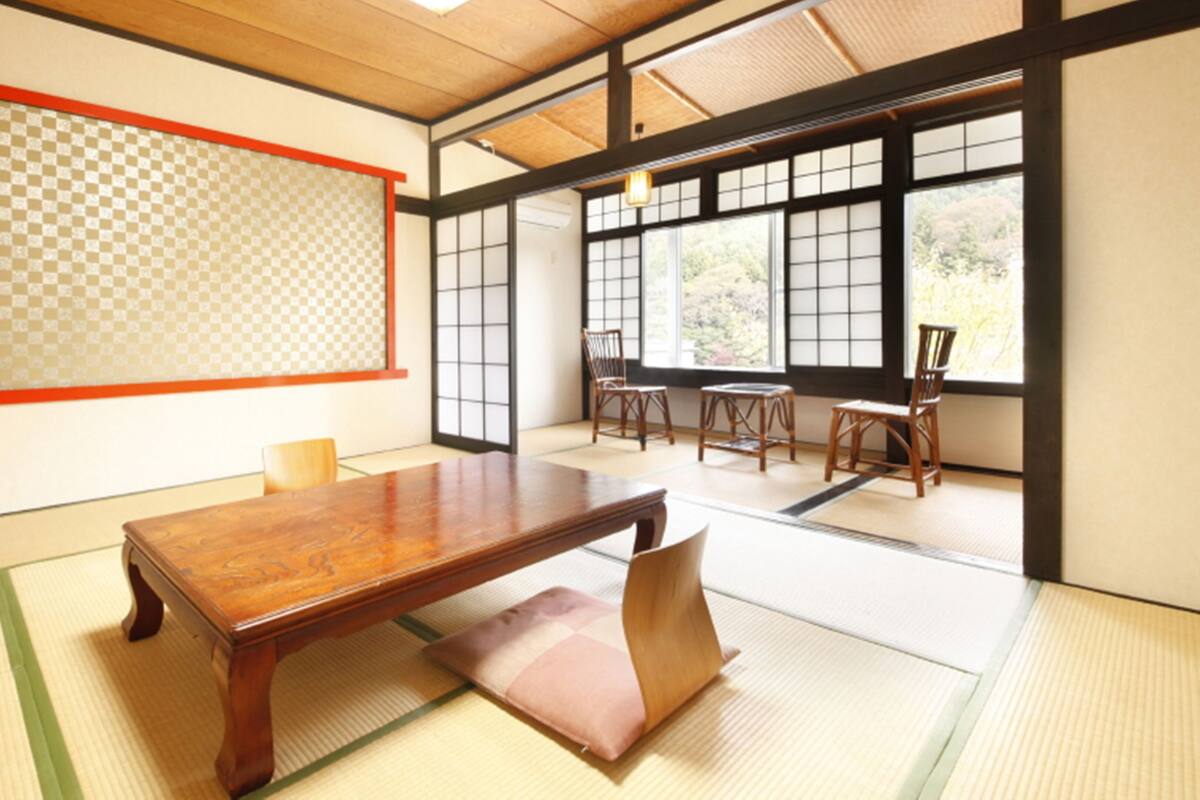 A traditional Japanese room with tatami flooring, a low wooden table, and sliding shoji doors.
