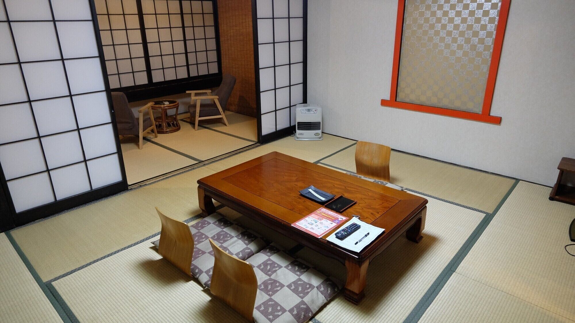 A traditional Japanese room with tatami flooring, a low wooden table, and a tatami mat bench.