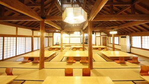 A traditional Japanese room with tatami mat flooring, wooden beams, and a central hanging light fixture. - The Aizuya (Nasushiobara)