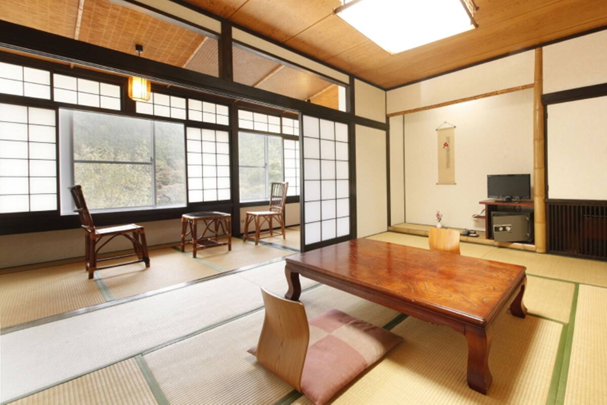 A traditional Japanese room with tatami flooring, a low wooden table, and sliding doors.