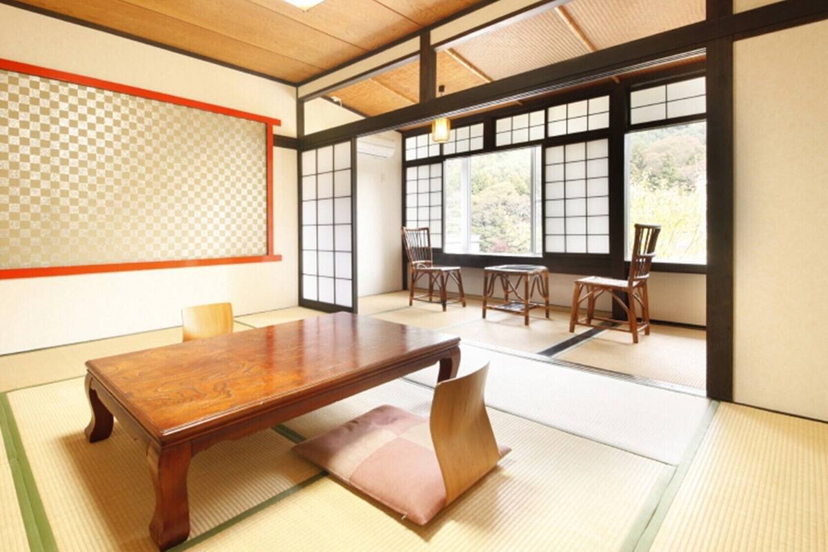 A traditional Japanese room with tatami flooring, a low wooden table, and sliding doors.