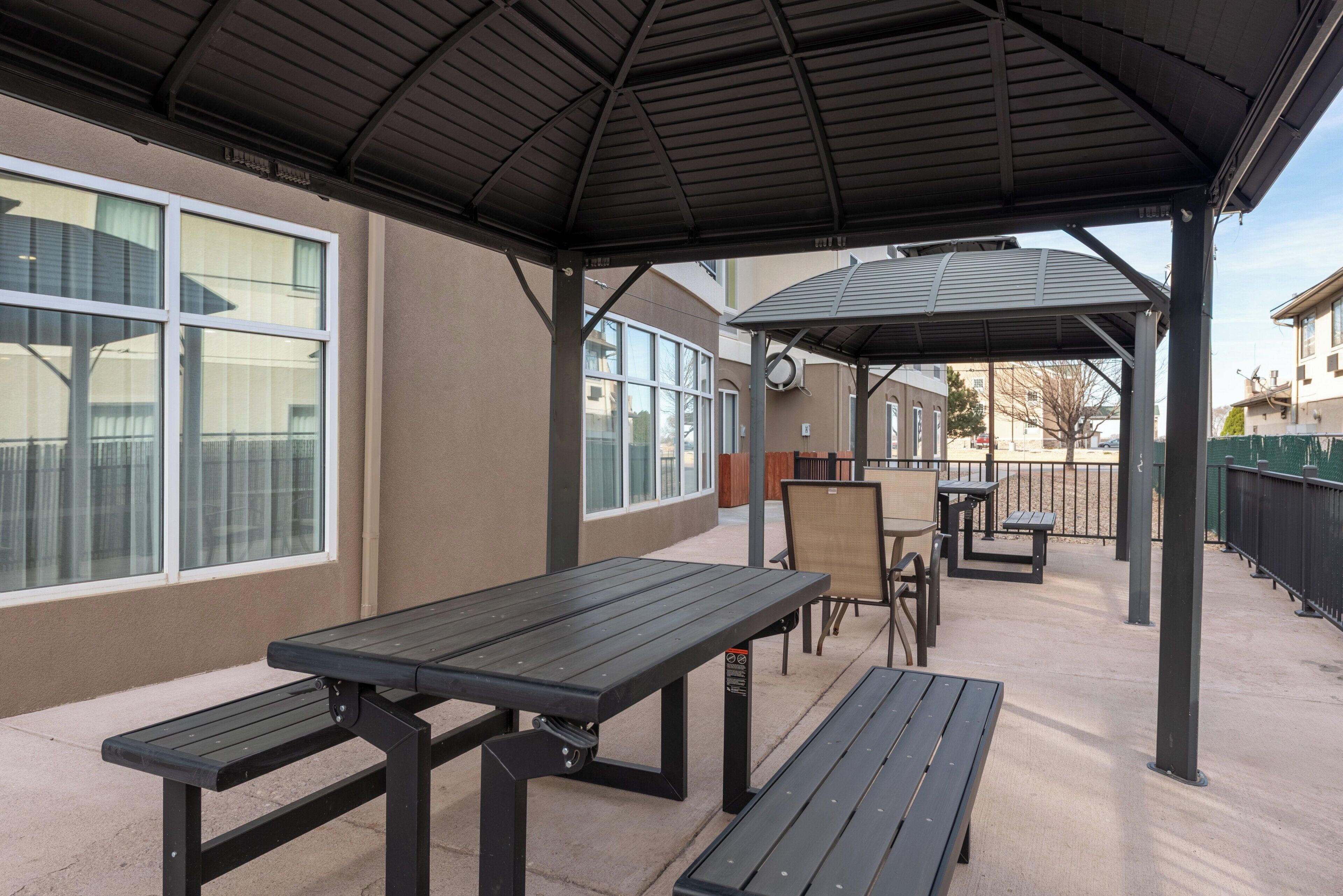 An outdoor patio area with picnic tables and a covered seating area.