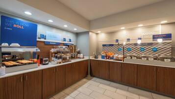A breakfast buffet area with labeled sections for bakery, cereal, fruit, hot food, and egg-xactly.